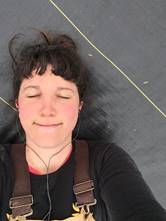 Kristin Pearson, Farmer and CSA Owner, relaxing by lying on the road